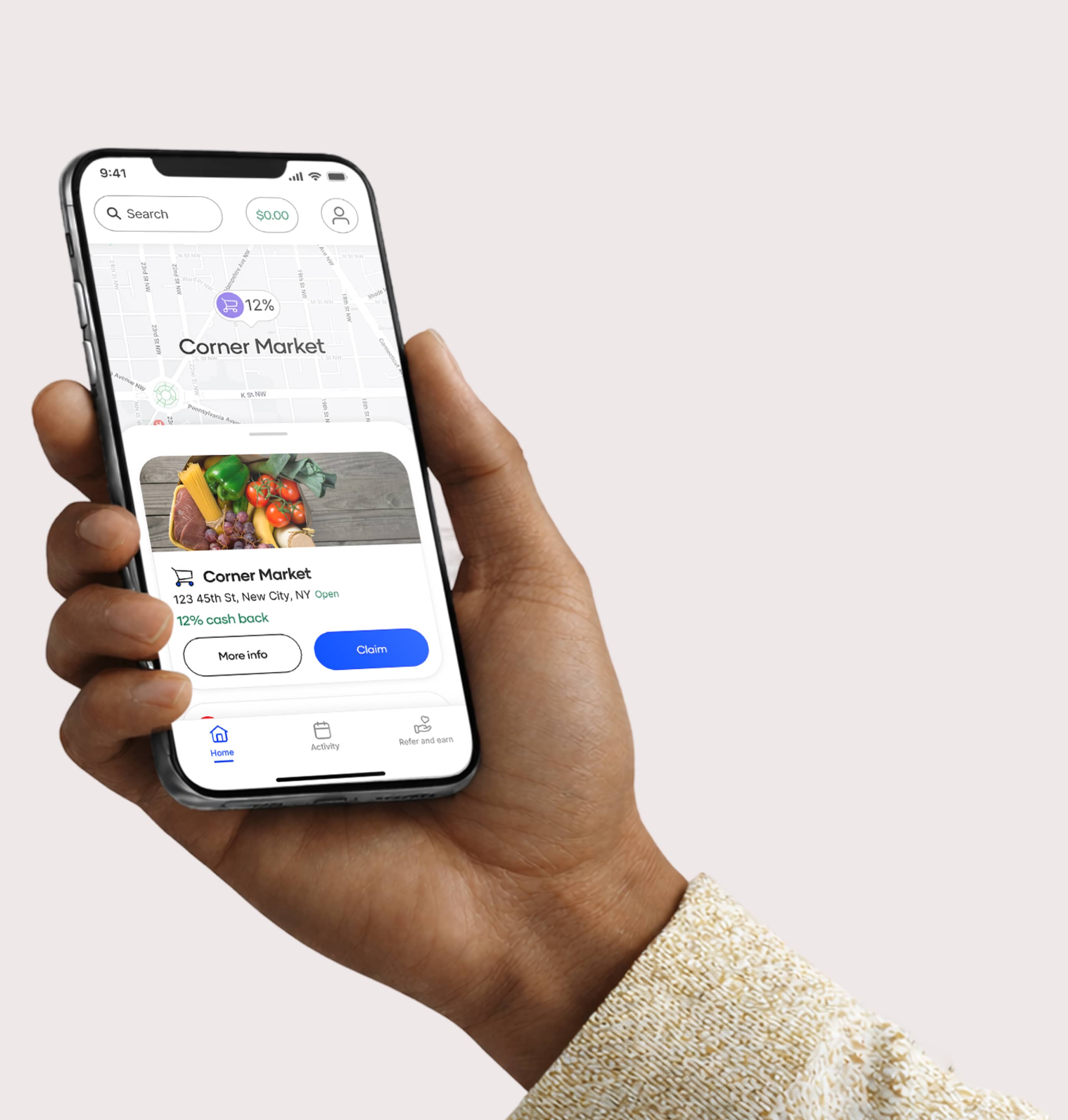 A person holds a smartphone displaying a shopping rewards app with a map and a listing for "Corner Market" offering "12% cash back" at "123 45th St, New City, NY Open". The screen shows buttons labeled "More info" and "Claim" along with navigation icons for "Home", "Activity", and "Refer and earn".