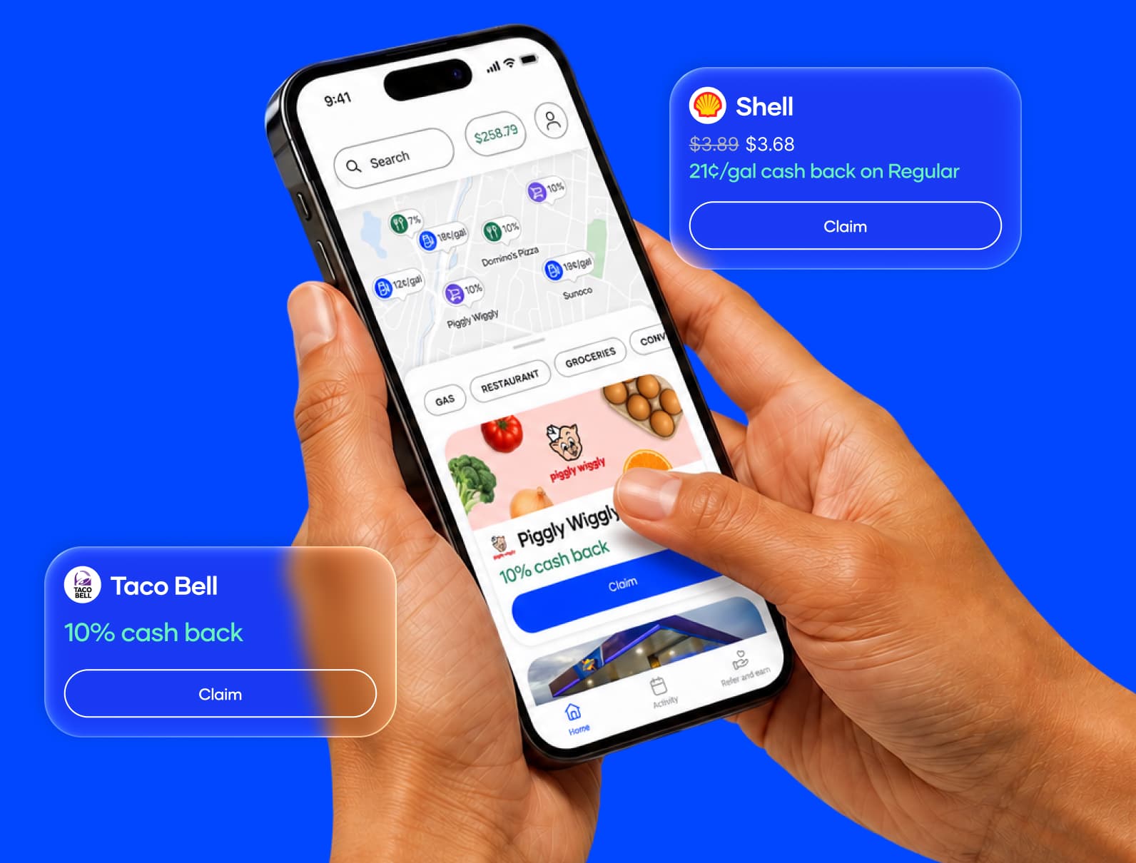 Two hands hold a smartphone displaying a cashback app with a map of nearby offers and a grocery cashback deal for Piggly Wiggly against a solid blue background.