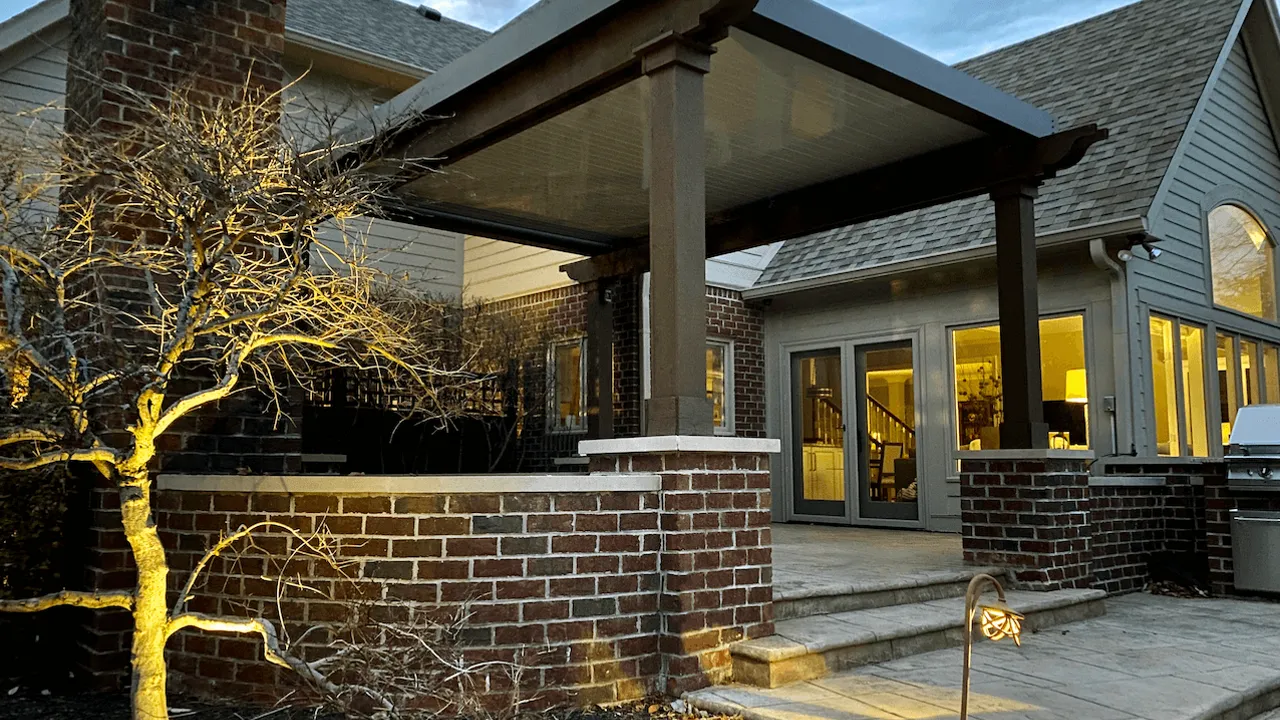 A motorized pergola covers the patio of a nice house.