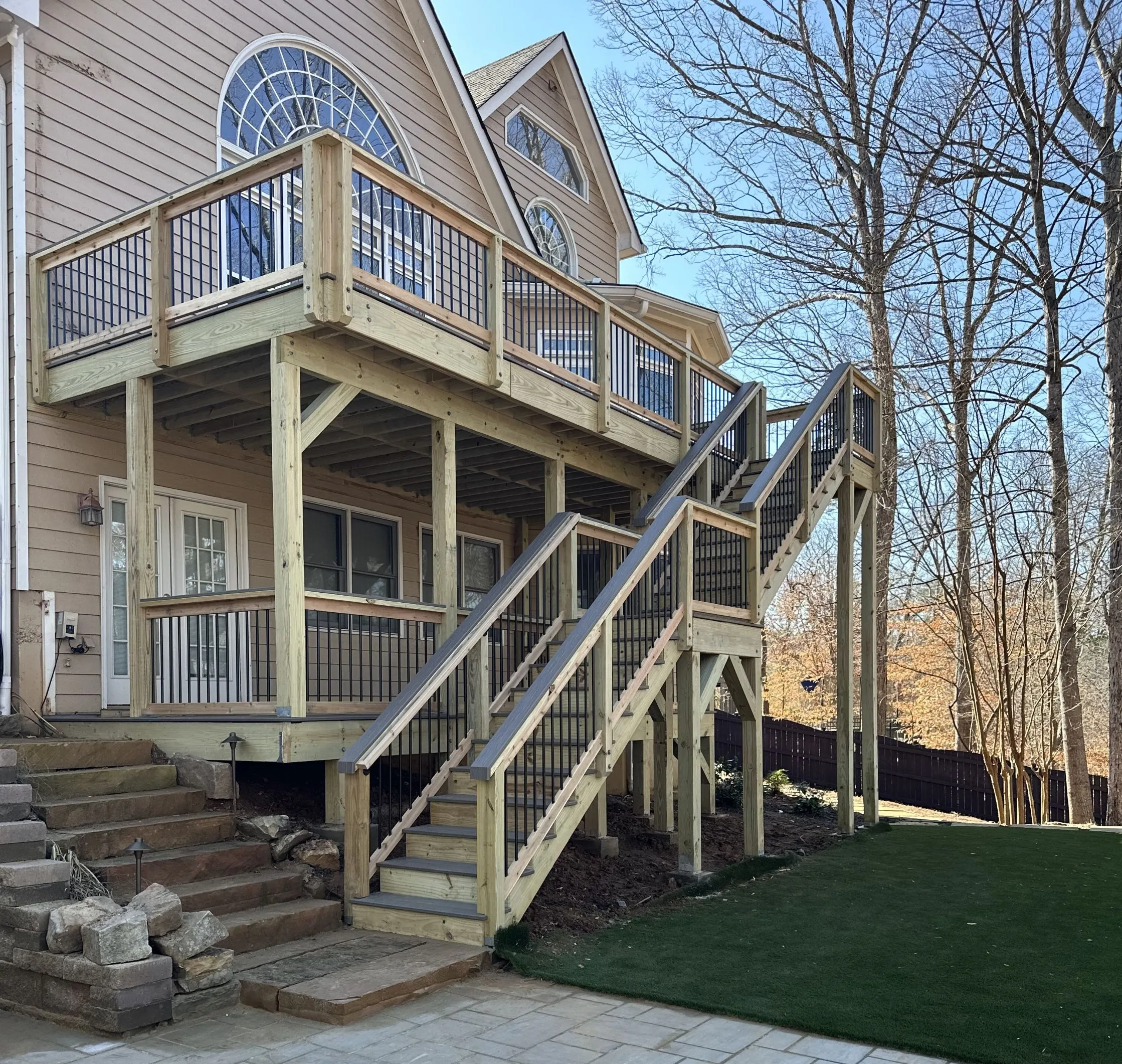 An experienced Builders America builder measuring planks as he builds a custom deck made of wood