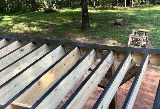A custom deck addition made of wood built on the back of a North Georgia home in the woods