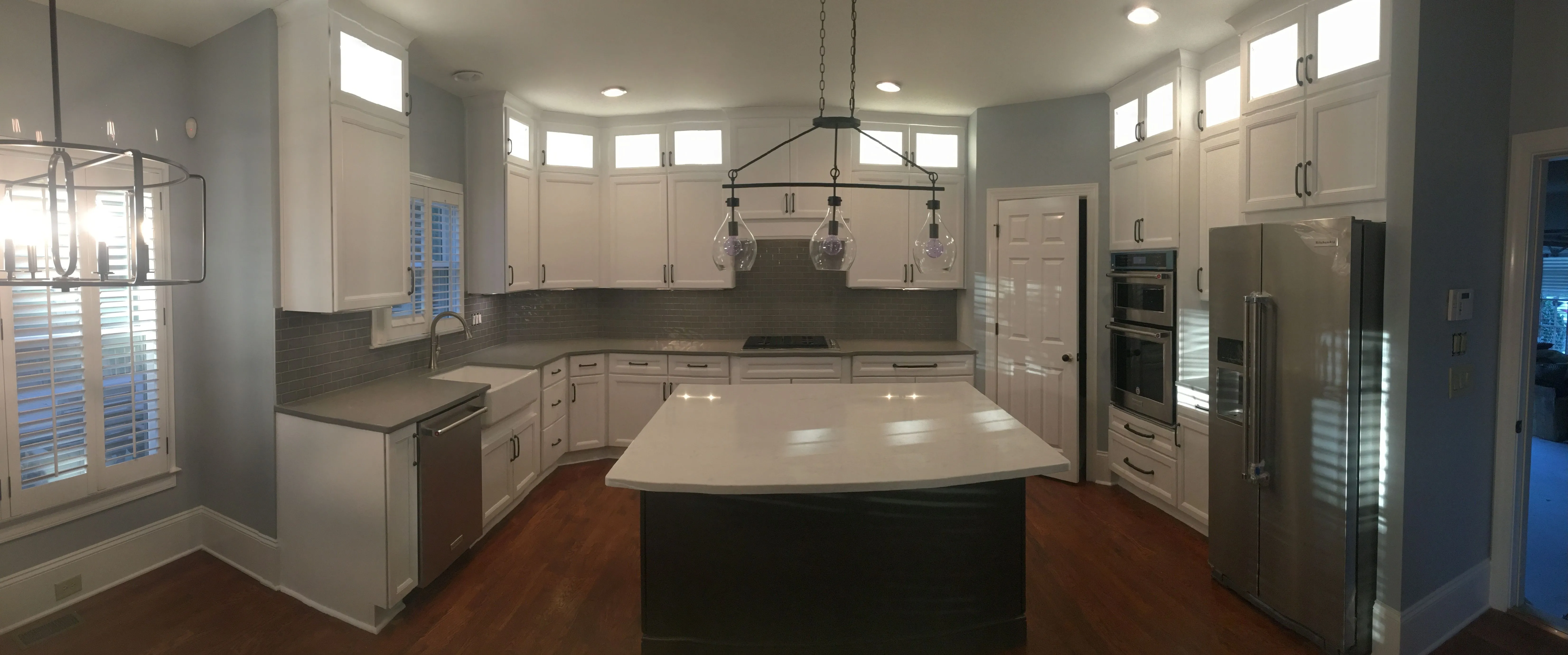 A spacious kitchen by Builders America featuring white cabinets and white quartz tops