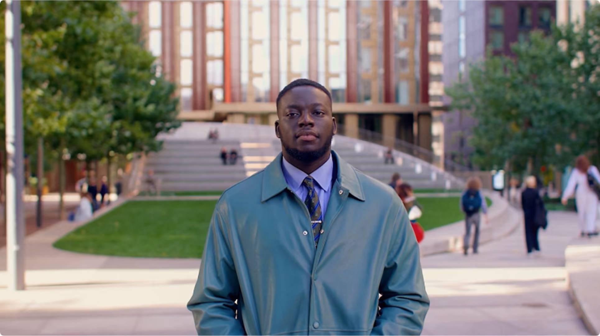 Young man in a coat standing in an urban plaza, from BPP University's 'A Lawyer Looks Like Me' campaign