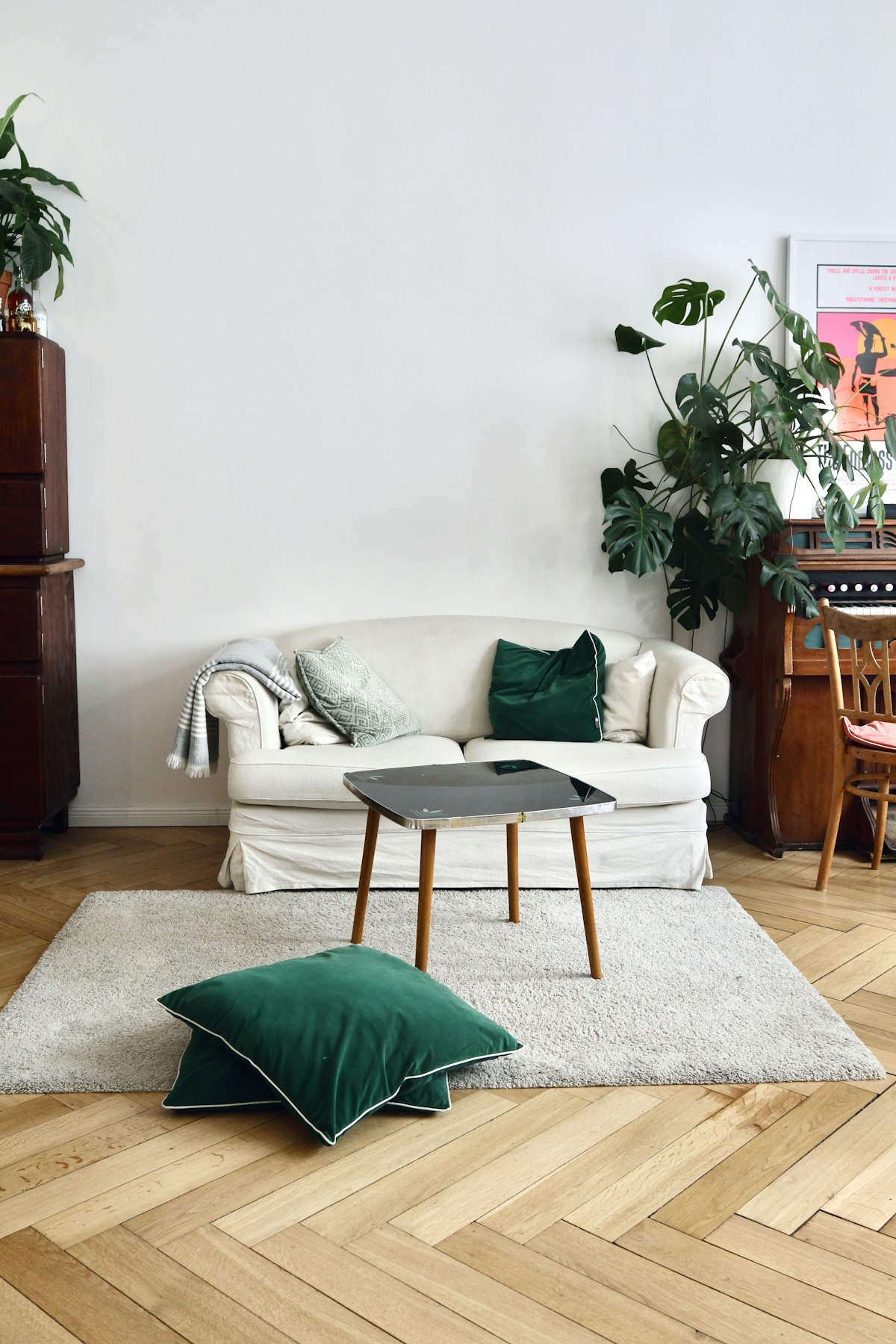 A neatly arranged sofa with a green cushion and soft natural lighting in a Singapore-style living room