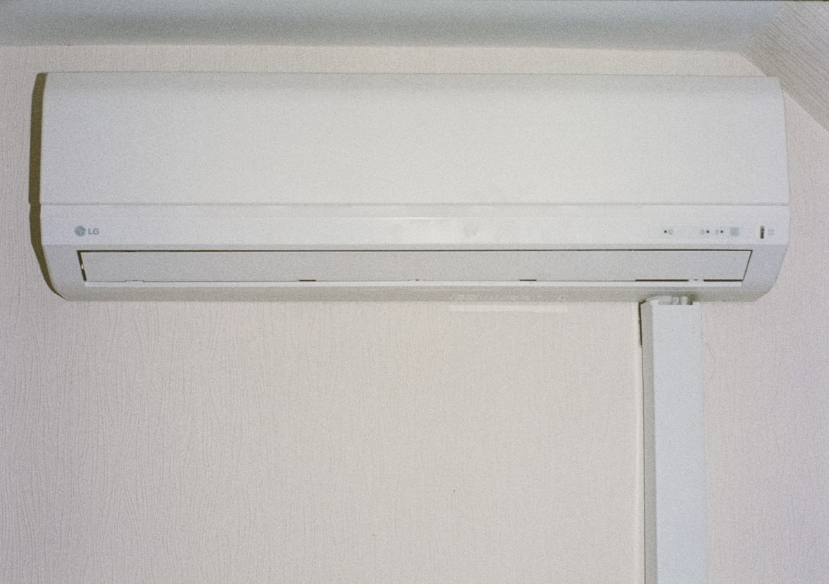 A white wall-mounted air conditioner indoor unit in a bright modern room