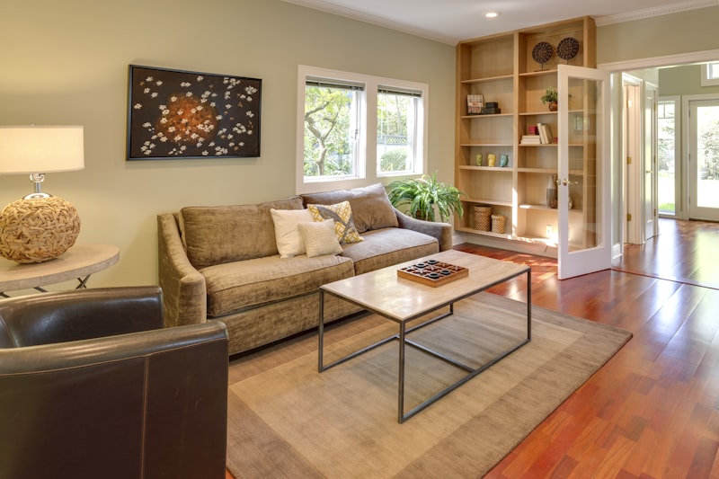 Warm modern living room with a sofa, bookshelf and a clean wooden floor