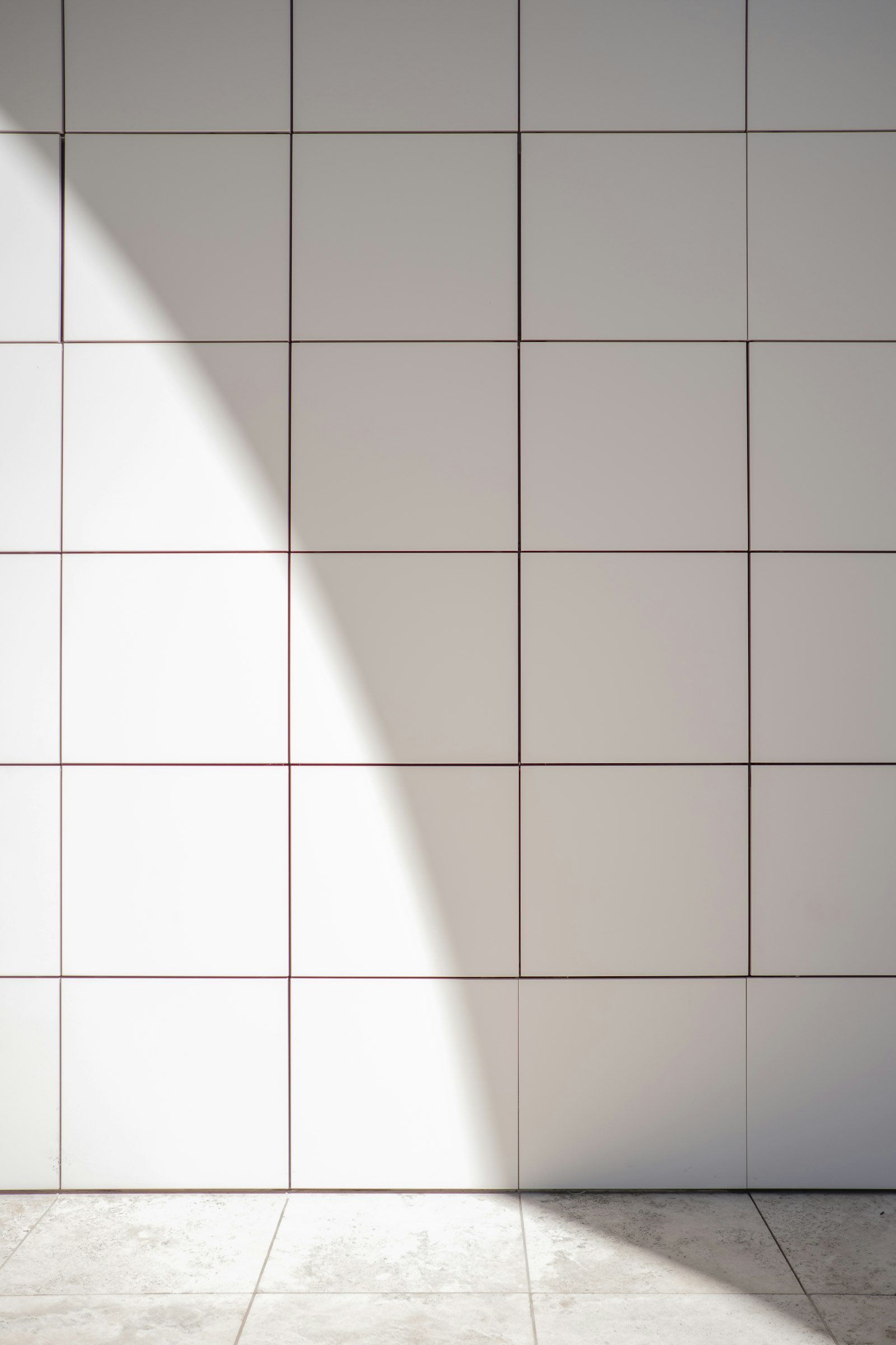 Clean white and grey ceramic floor tiles with neat grout lines