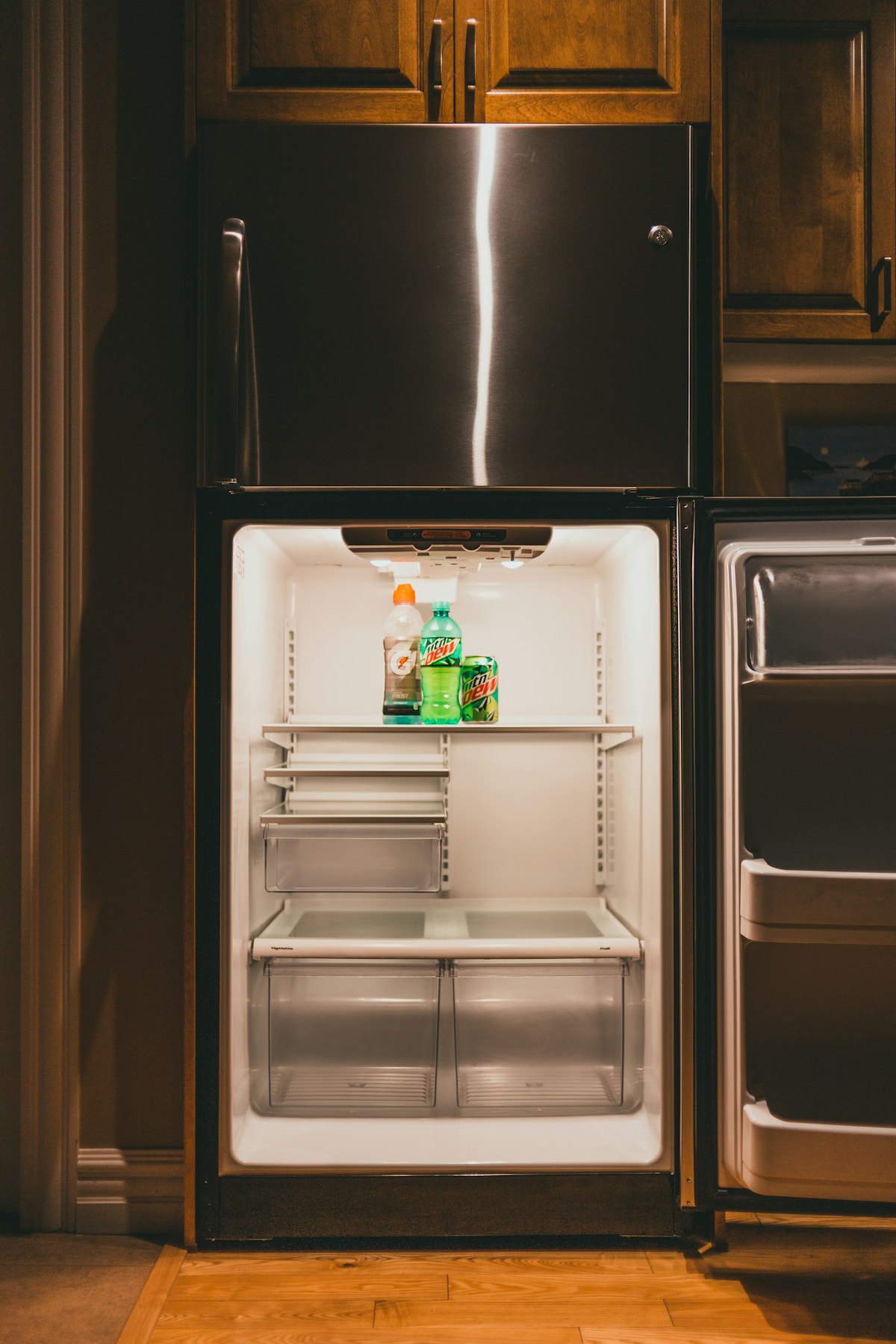 A clean, freshly wiped refrigerator interior with empty shelves