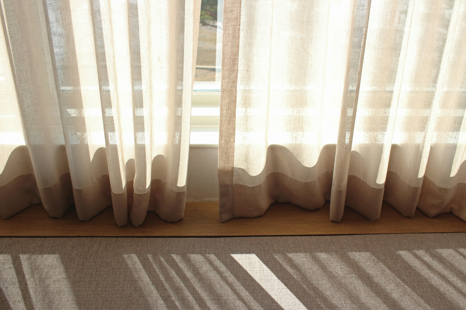 A bright window with a soft white curtain drifting in natural daylight