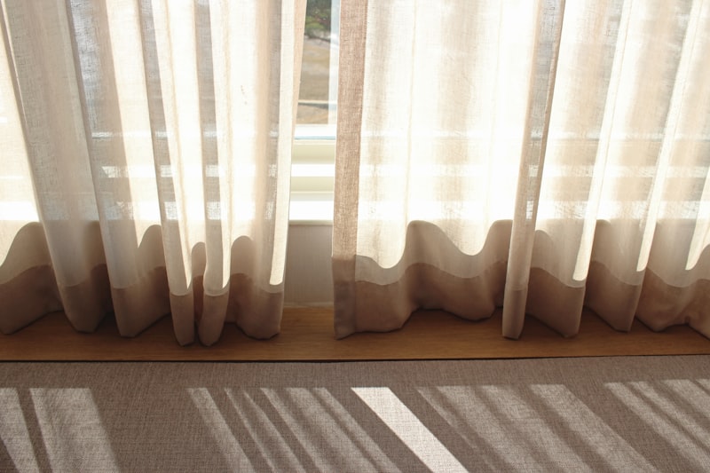 A bright window with a soft white curtain drifting in natural daylight