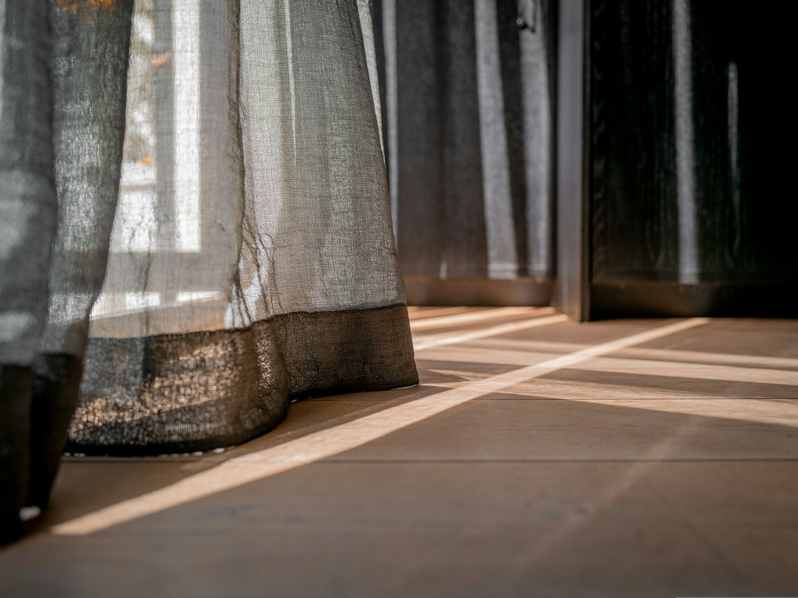 A close-up of a soft curtain resting on a window sill in natural light