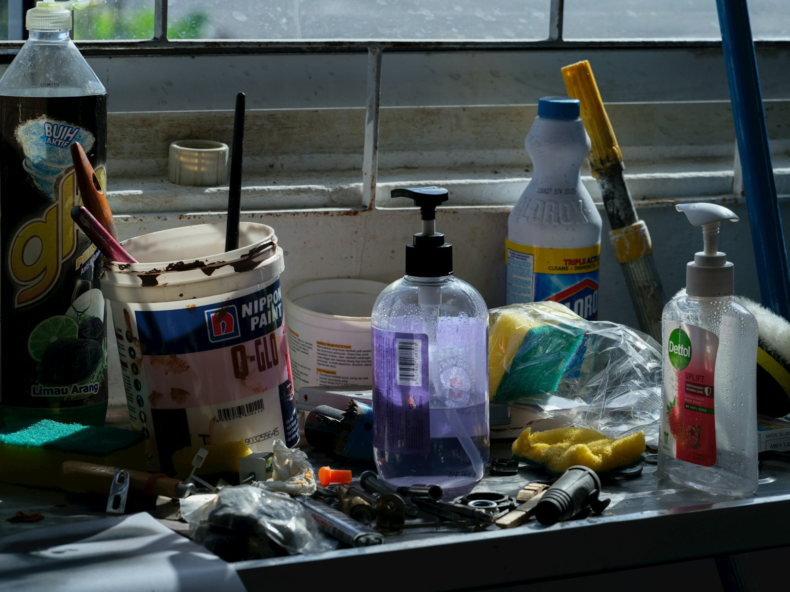 An assortment of cleaning supplies and tools laid out on a counter