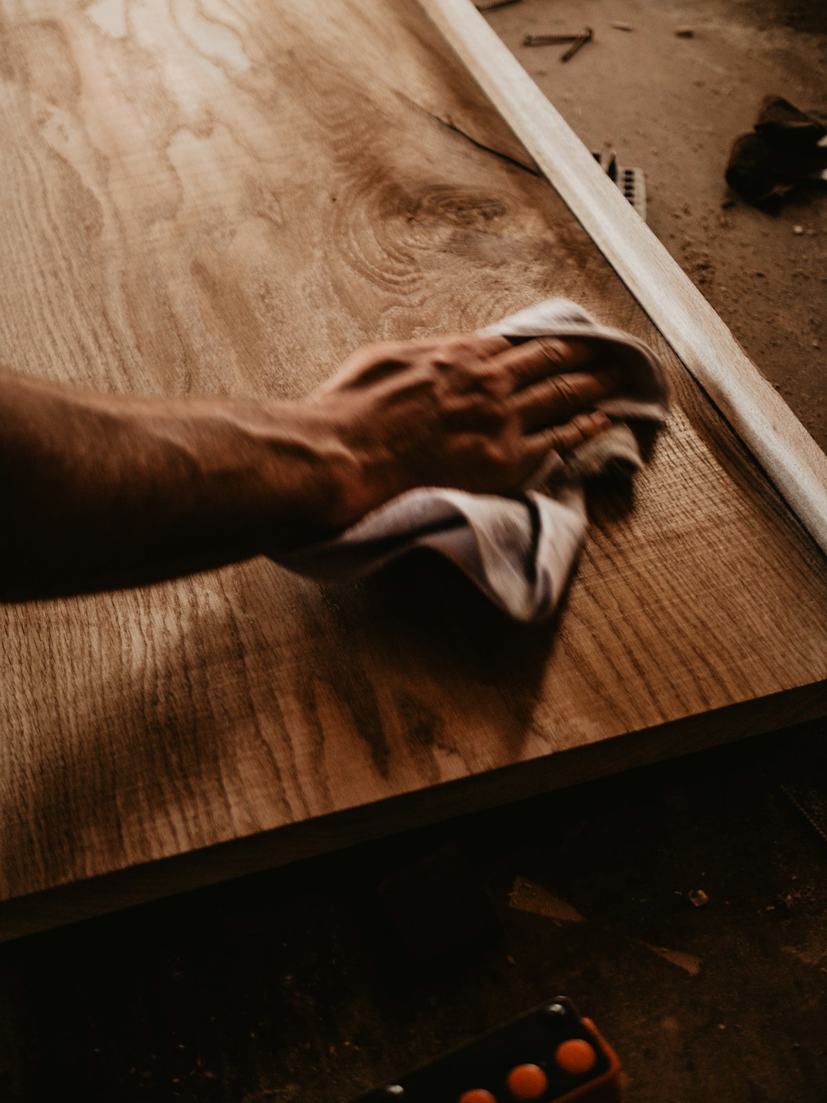 A cloth wiping fine dust from a wooden surface