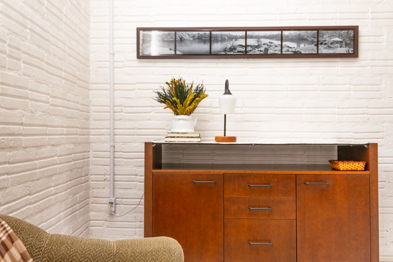 Mid-century wooden sideboard against a white brick wall in a living room