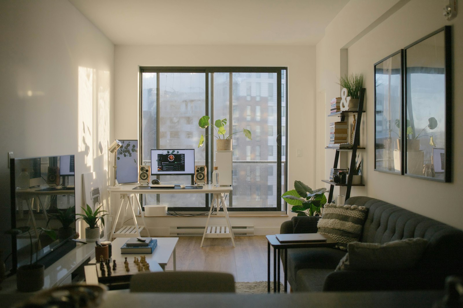 Compact high-rise flat with a wooden floor, plants and a desk by the window