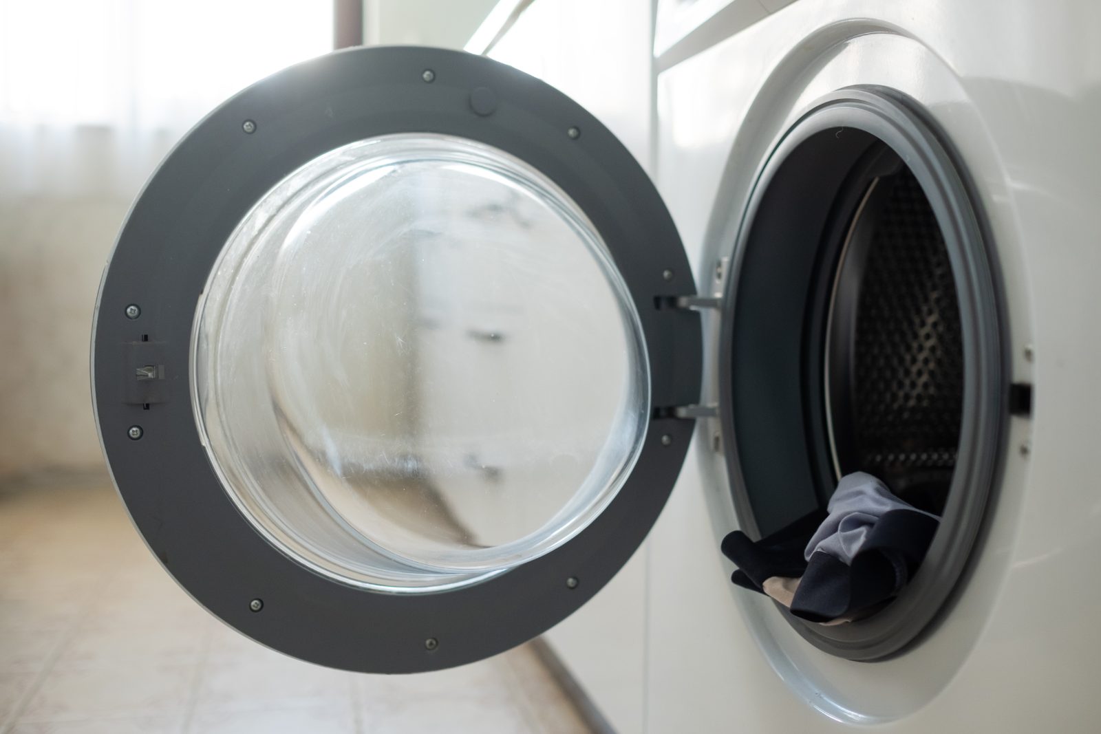 Open front-loading washing machine door showing the rubber seal and drum opening