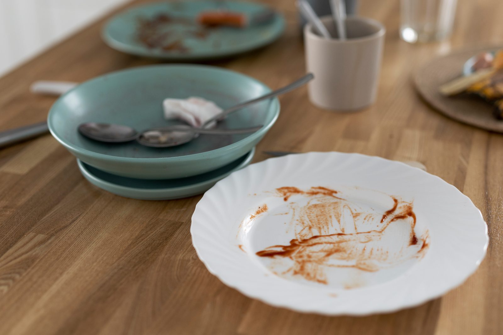 Used plates with sauce smears left on a wooden dining table after a meal