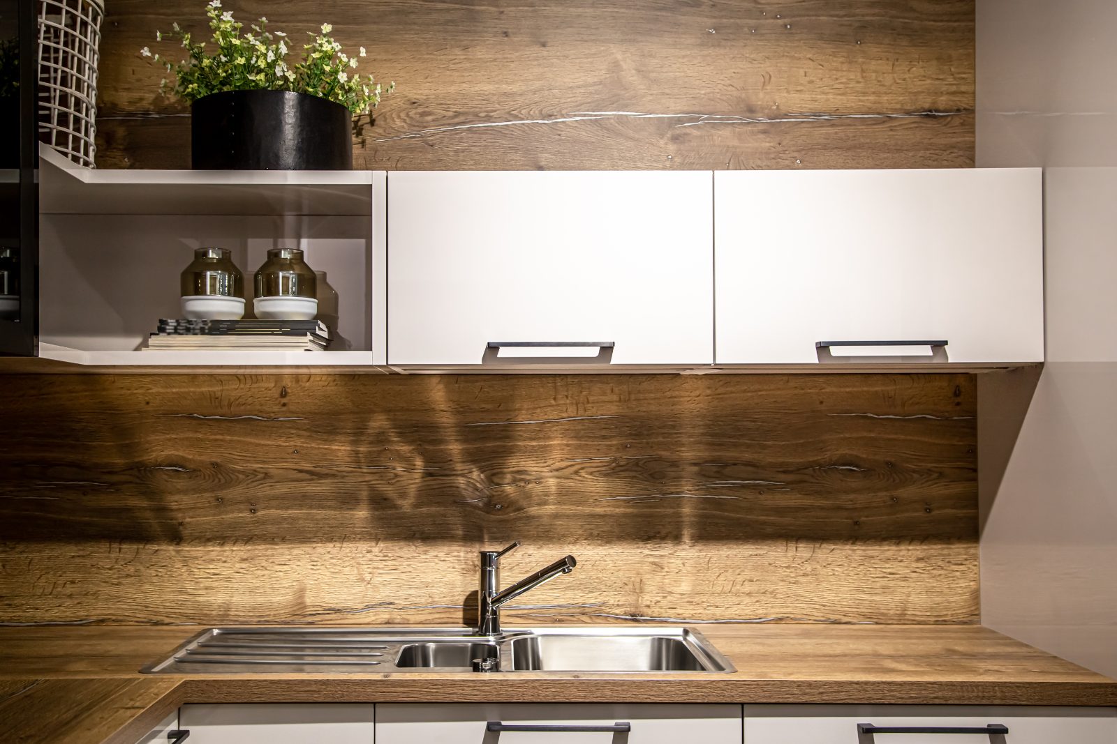 A timber kitchen worktop with an inset stainless steel sink and a timber splashback