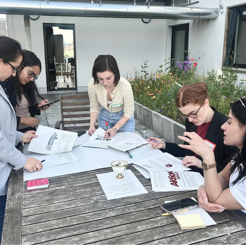 Five female NextGen Leaders working on a terrace and discussing topics
