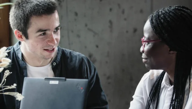 Two Kiron learners in front of a laptop talking to each other