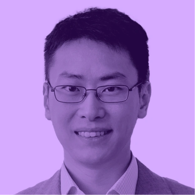 Portrait of a person with short hair and glasses, wearing a collared shirt and jacket, on a purple background