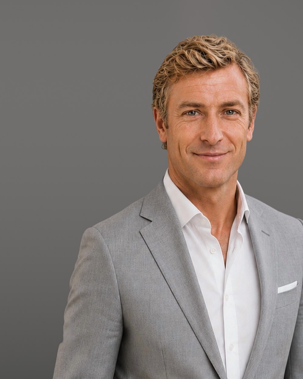 Professional in a light grey suit, smiling, on a grey background