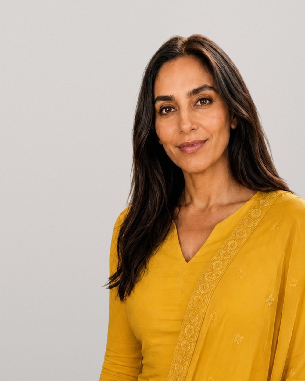 Professional with long dark hair in a yellow top