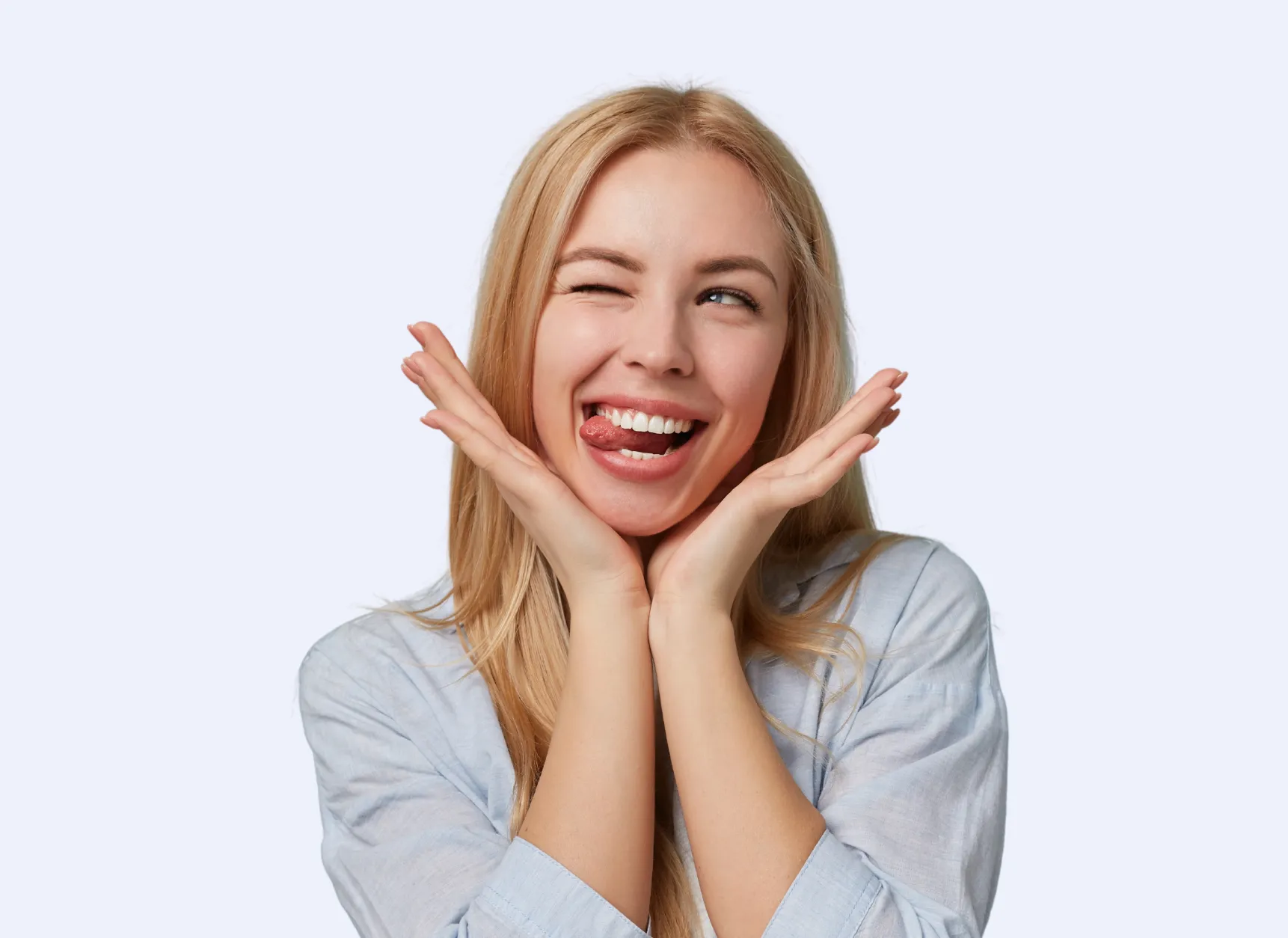 Smiling young man with arms crossed wearing a black t-shirt against a blue background.