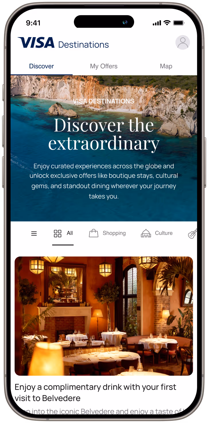 Mobile screen showing VISA Destinations app with scenic coastal banner and a warmly lit restaurant interior below.