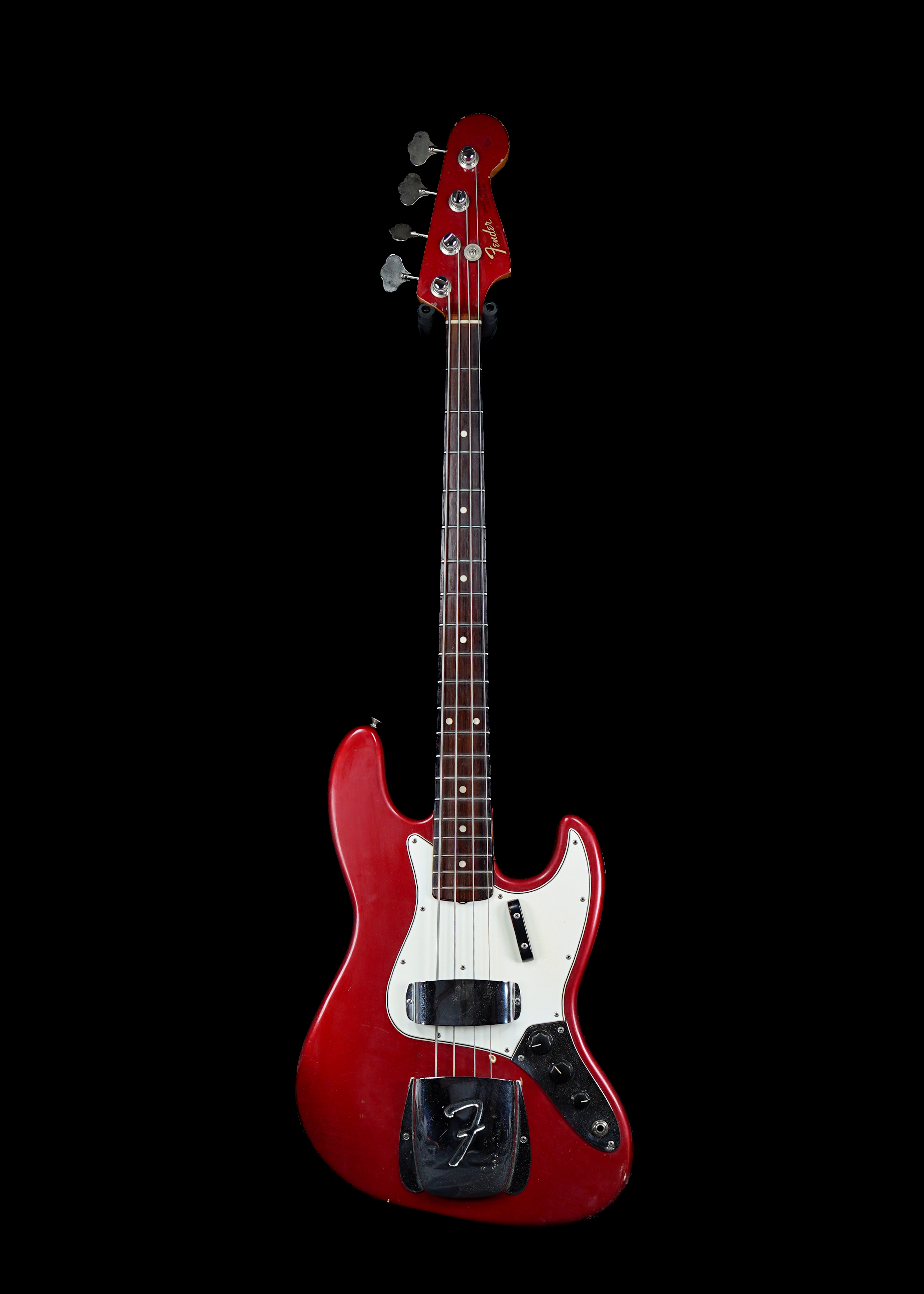a professional photo of a 1965 Fender Jazz Bass Candy Apple Red vintage bass guitar by Tone Brothers, the best place to sell my vintage bass guitar
