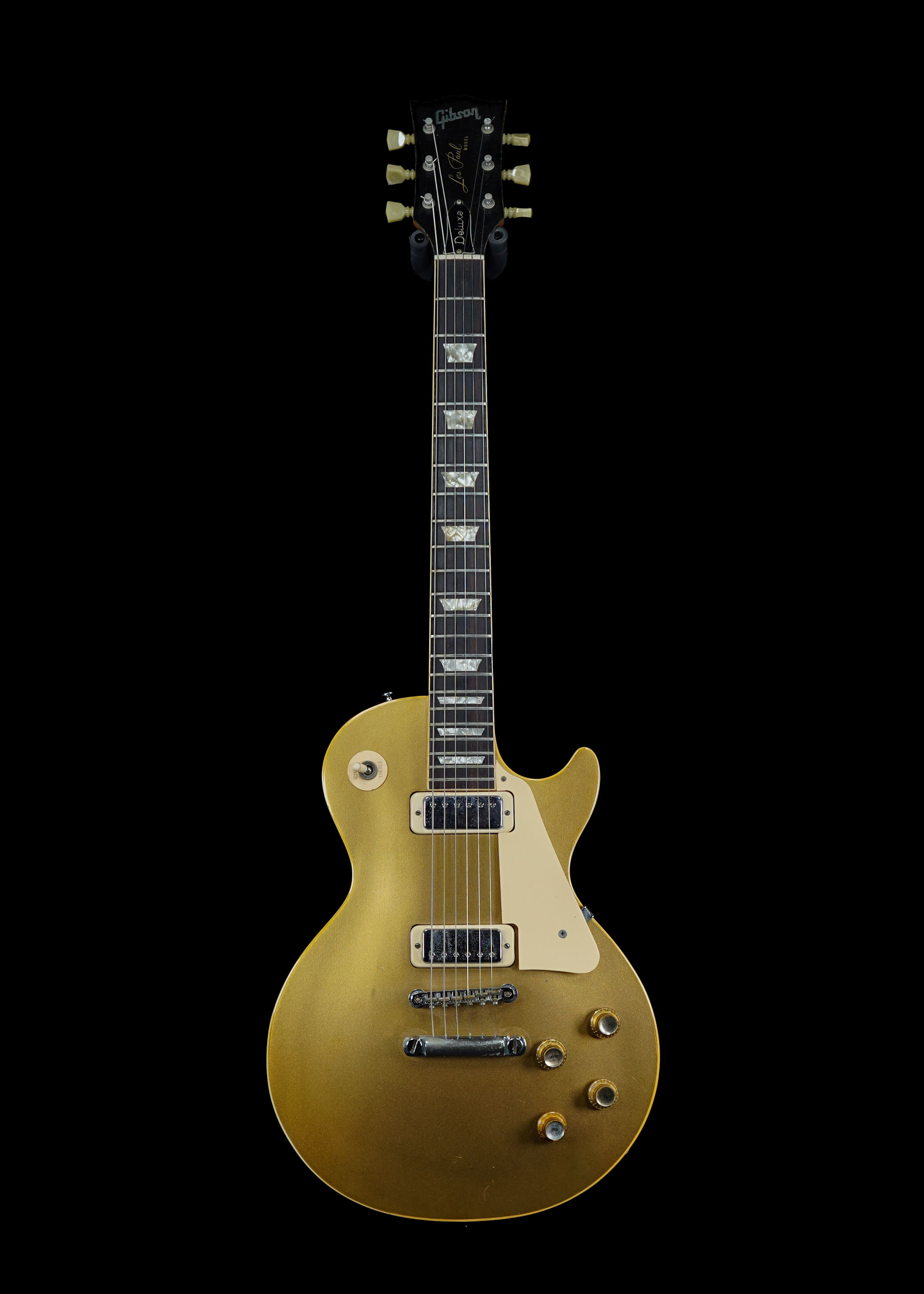 a professional photo of a 1973 Gibson Les Paul Deluxe Goldtop vintage guitar by Tone Brothers, the best place to sell my vintage guitar