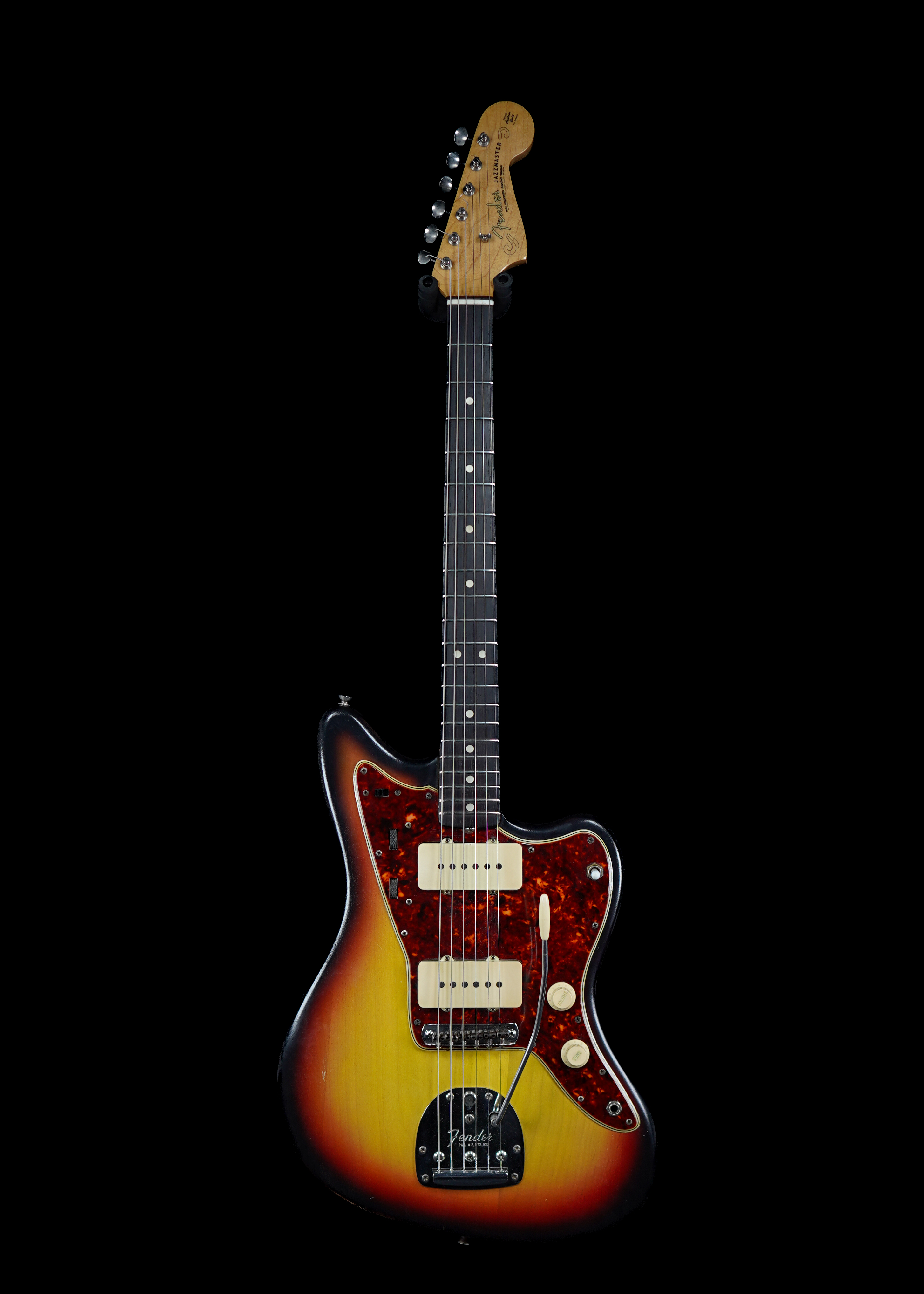 a professional photo of a 1965 Fender Jazzmaster Sunburst vintage guitar by Tone Brothers, the best place to sell my vintage guitar