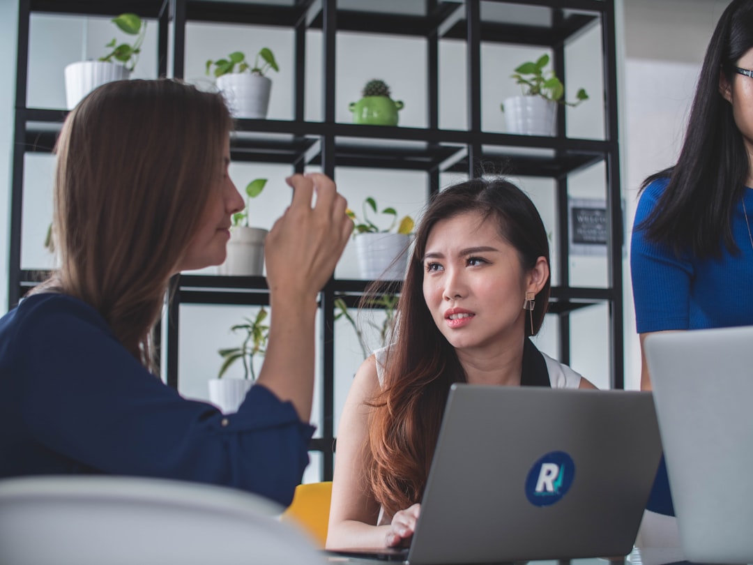 Seorang pengusaha wanita Asia sedang membandingkan berbagai pilihan di laptopnya di sebuah kantor modern — Foto oleh Mimi Thian di Unsplash