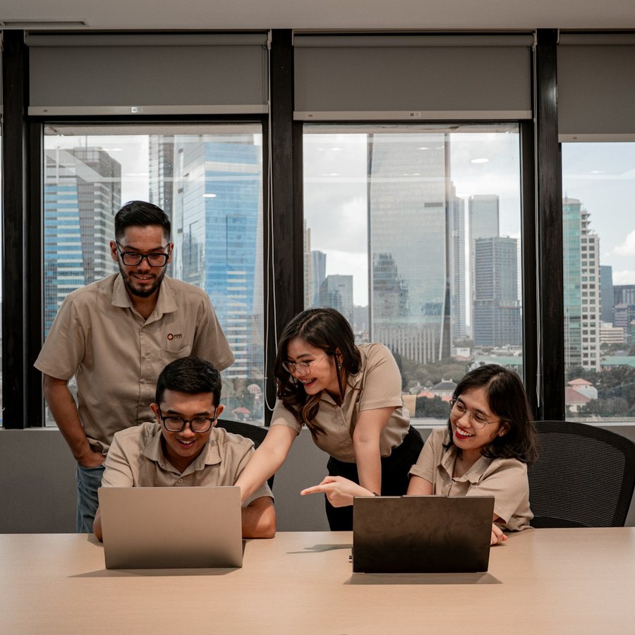 Team collaborating on laptops in modern office