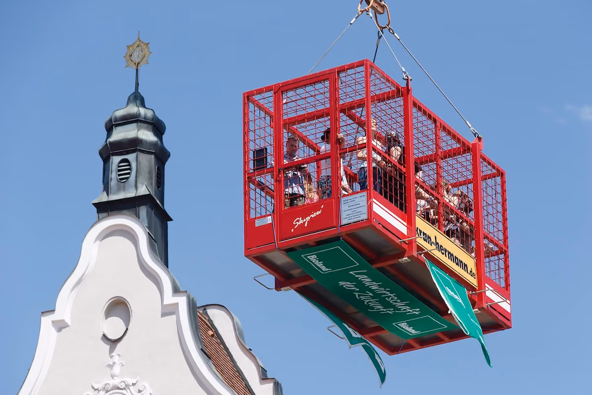 Besucherinnen und Besucher schweben 2017 in einer roten Gondel über der Altstadt.