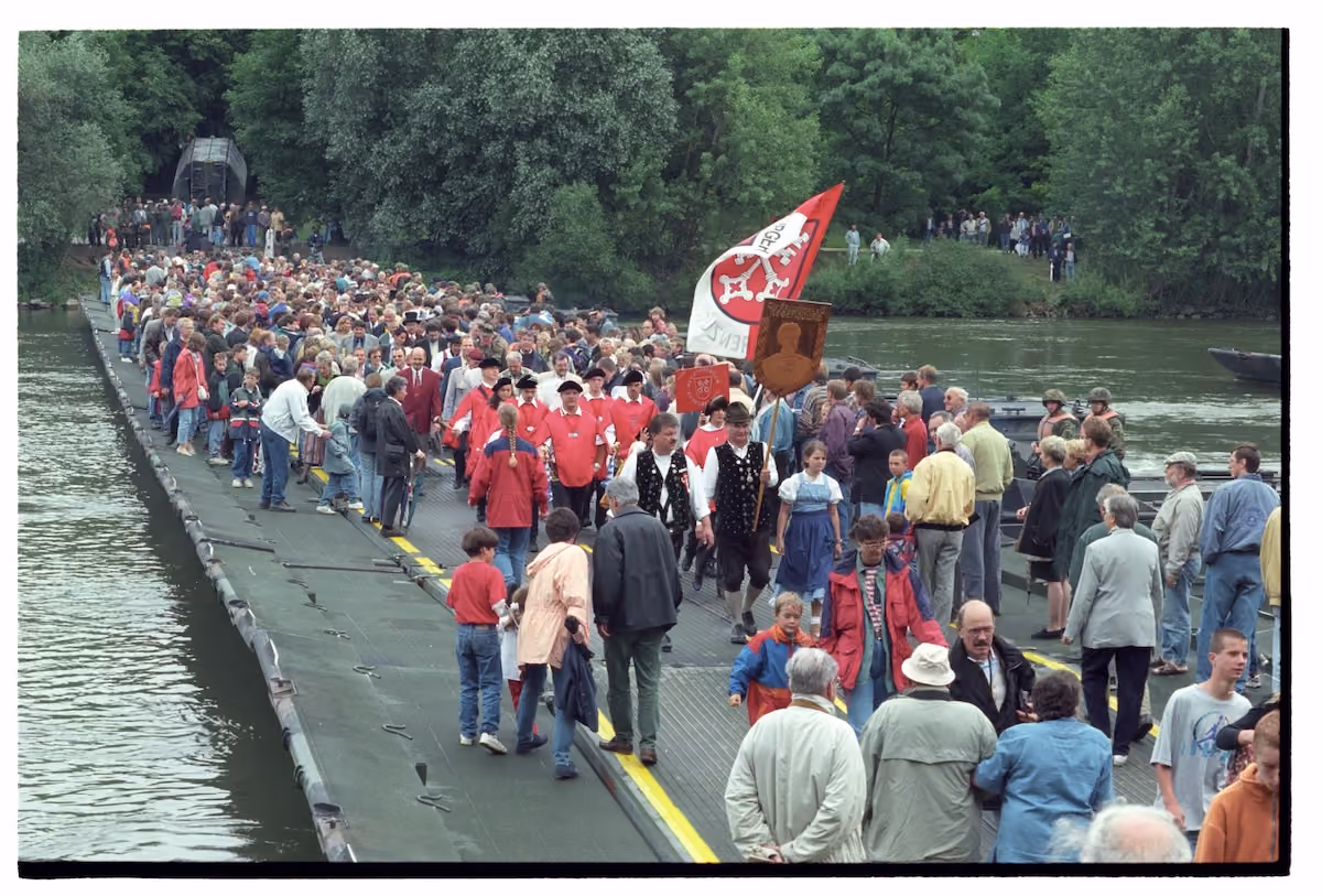 Festzug mit Trachtengruppen und vielen Gästen auf einer Behelfsbrücke beim Bürgerfest 1997.