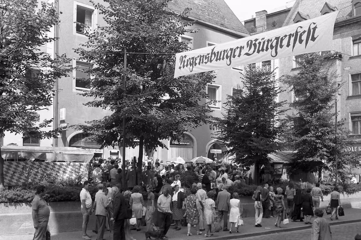 Besucherinnen und Besucher unter einem Banner mit der Aufschrift „Regensburger Bürgerfest“ im Jahr 1973.