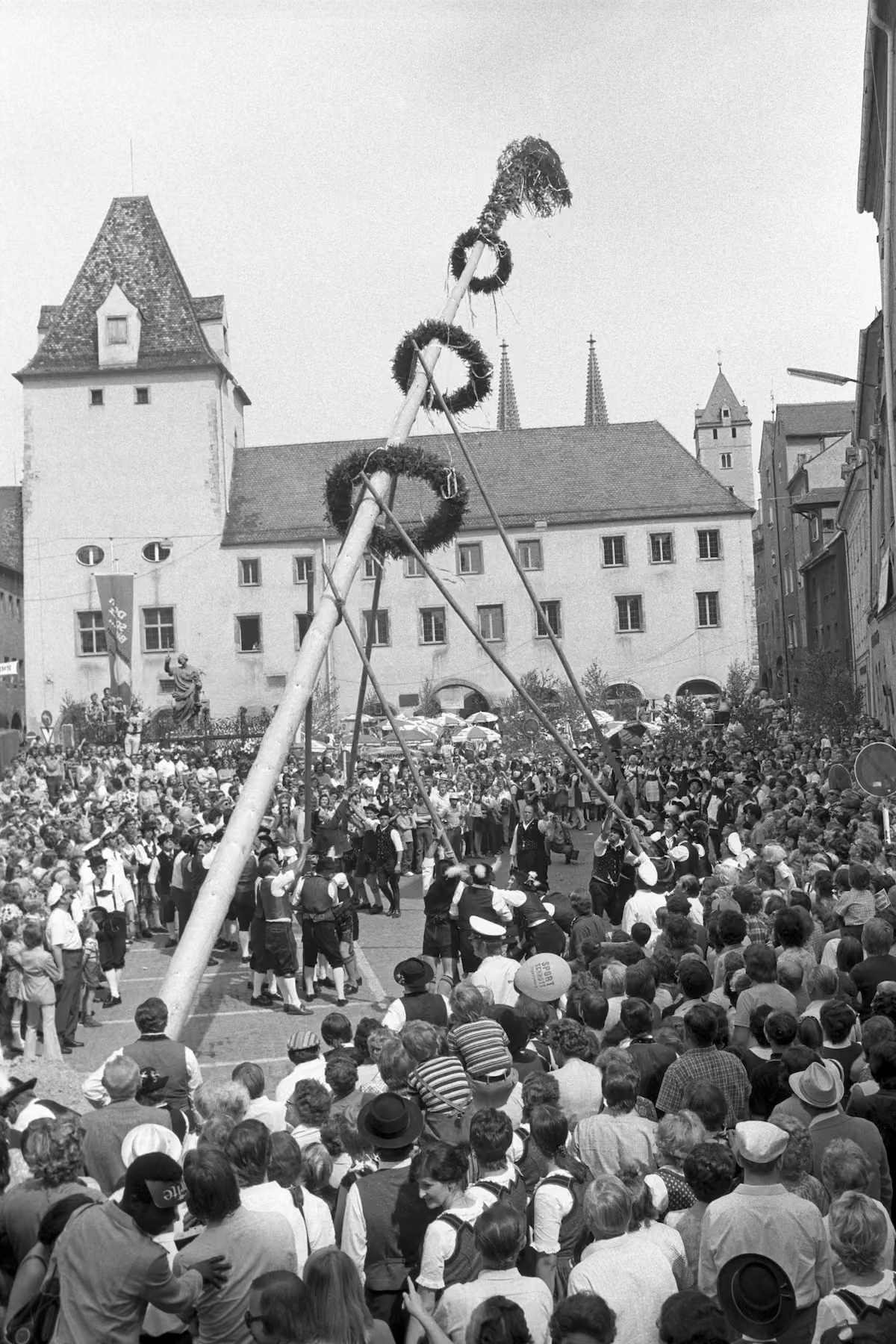 Traditionelles Aufstellen eines geschmückten Festbaums vor einer großen Menschenmenge beim ersten Regensburger Bürgerfest 1973.