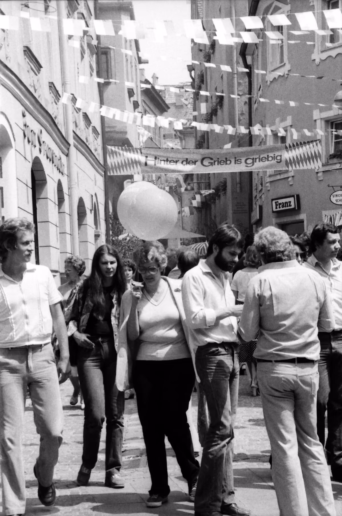 Festgäste in einer mit Fähnchen geschmückten Altstadtgasse beim Regensburger Bürgerfest 1979.