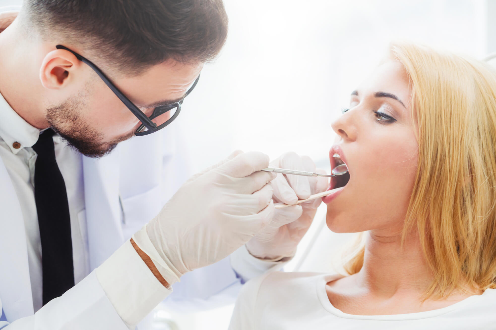 Cosmetic Dentist Pompano Beach checking patient's mouth