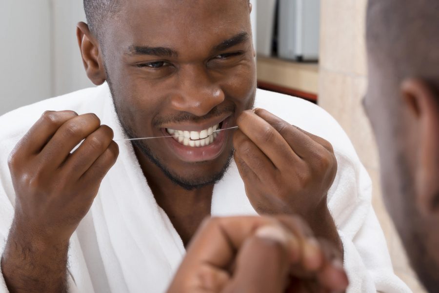 Using floss by a dentist in Pompano Beach