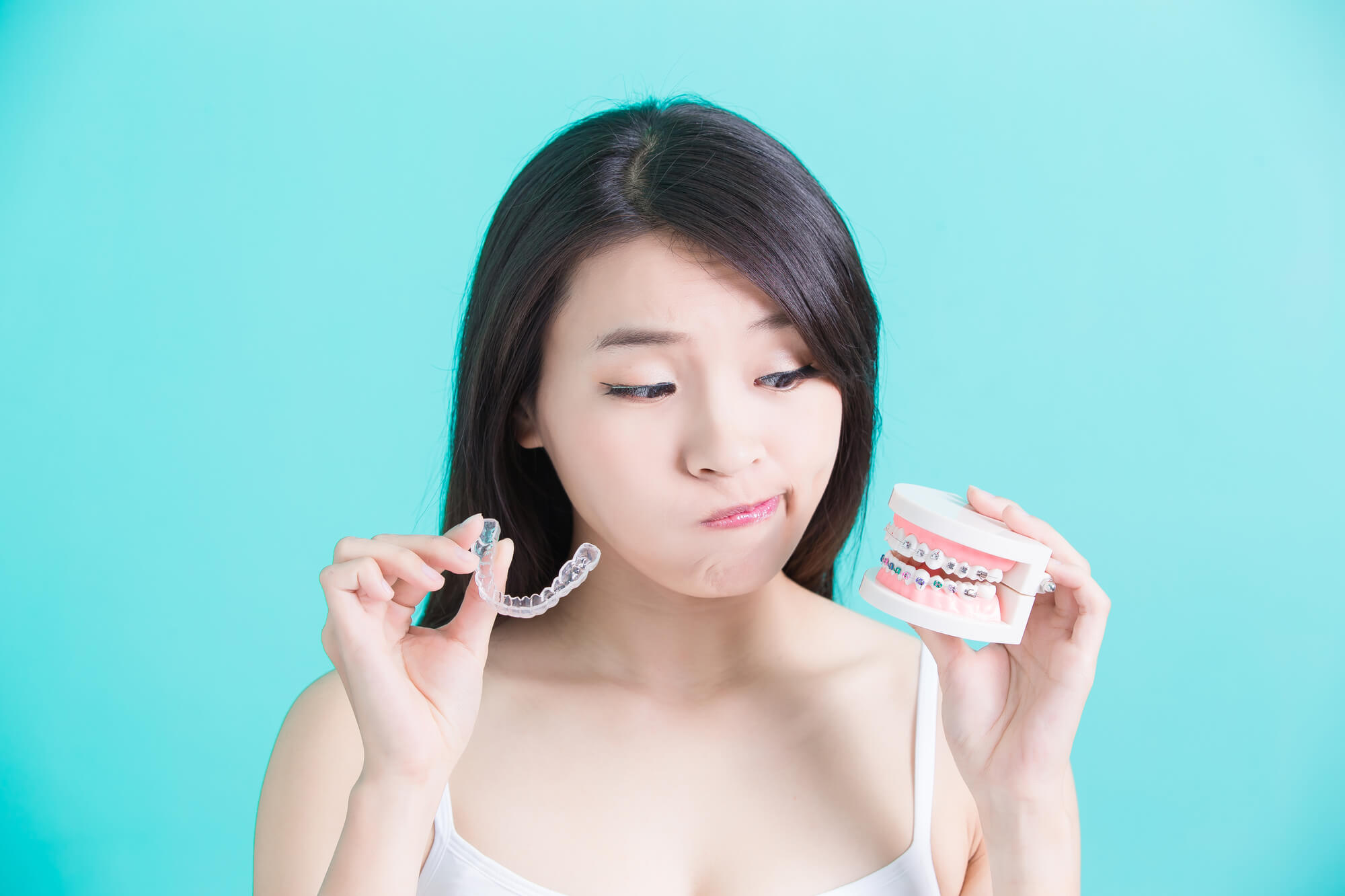 Asian woman choosing between braces and Invisalign® Pompano Beach