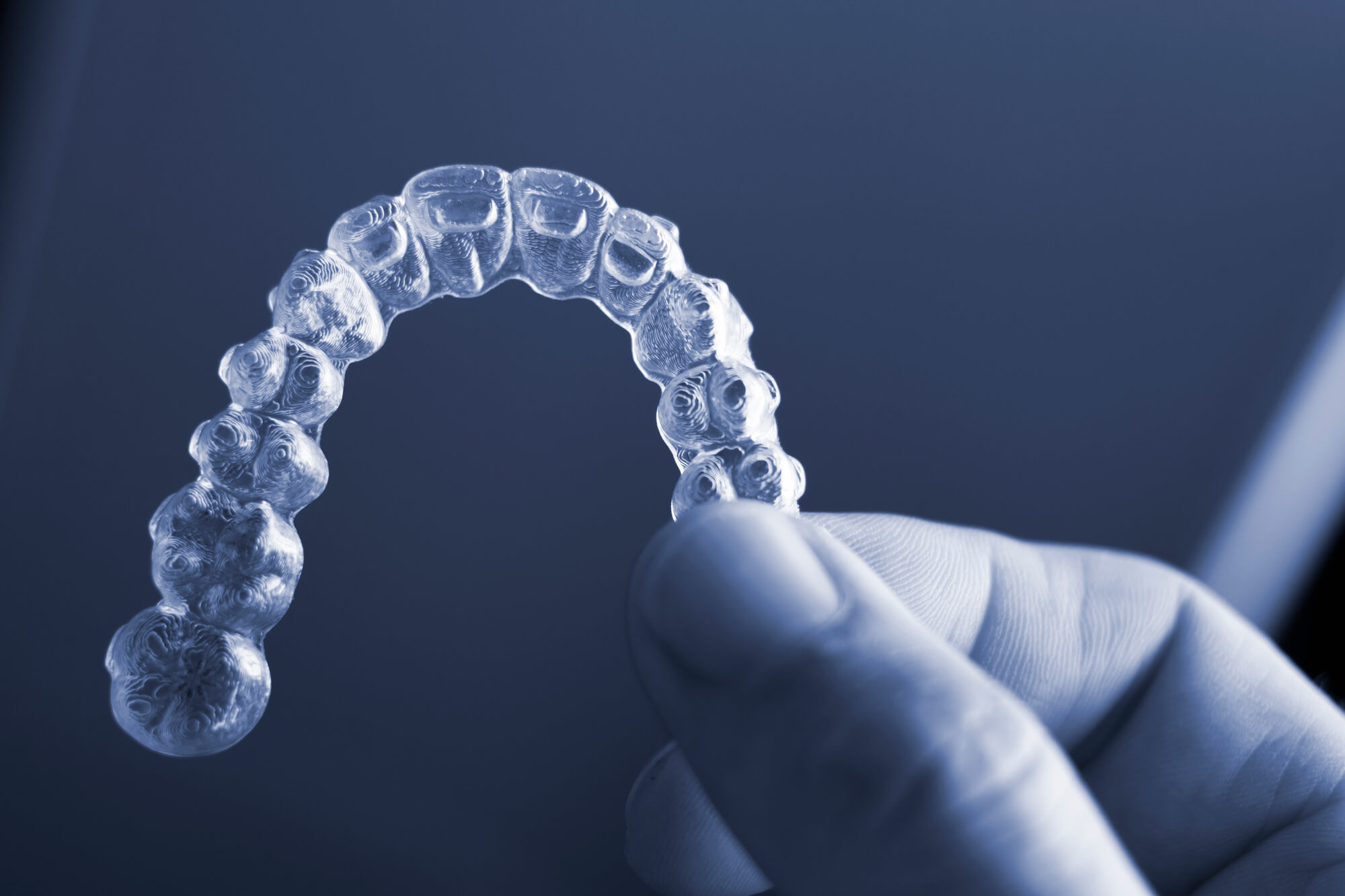 close up hand holding Invisalign in Pompano Beach
