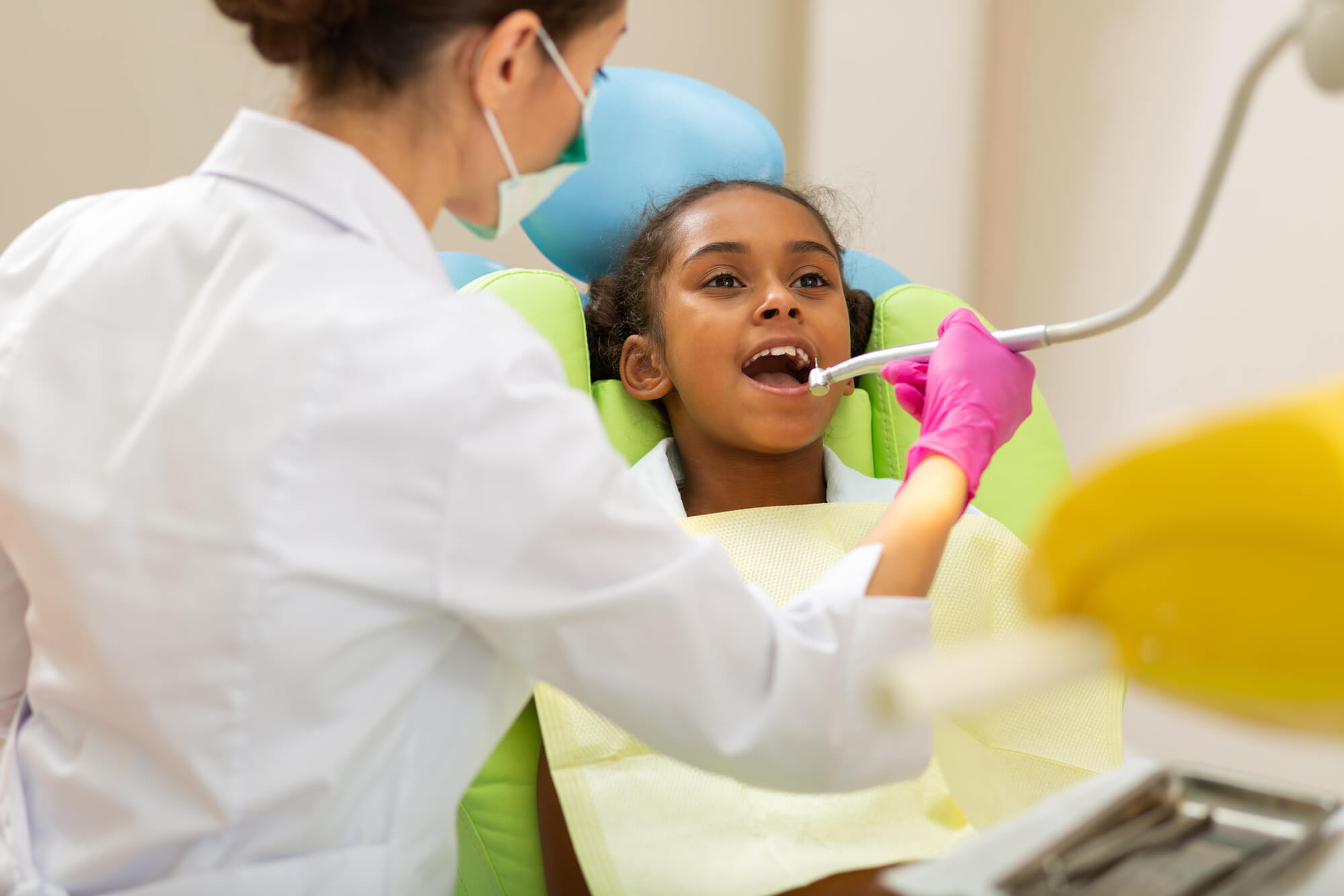 Dentist in Pompano Beach checking black girl's teeth
