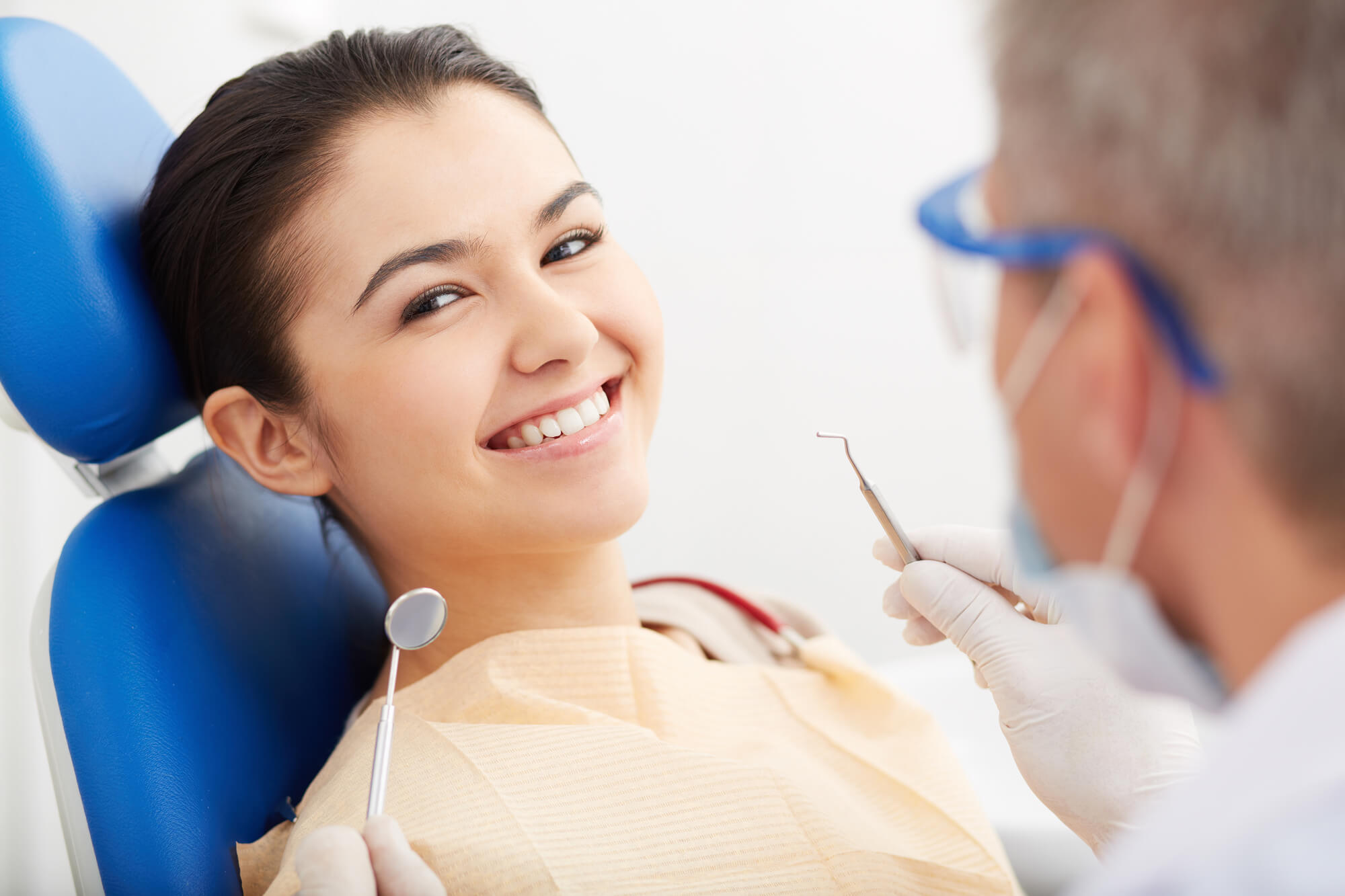 patient smiling in a dentist office after getting dental implants in Pompano Beach