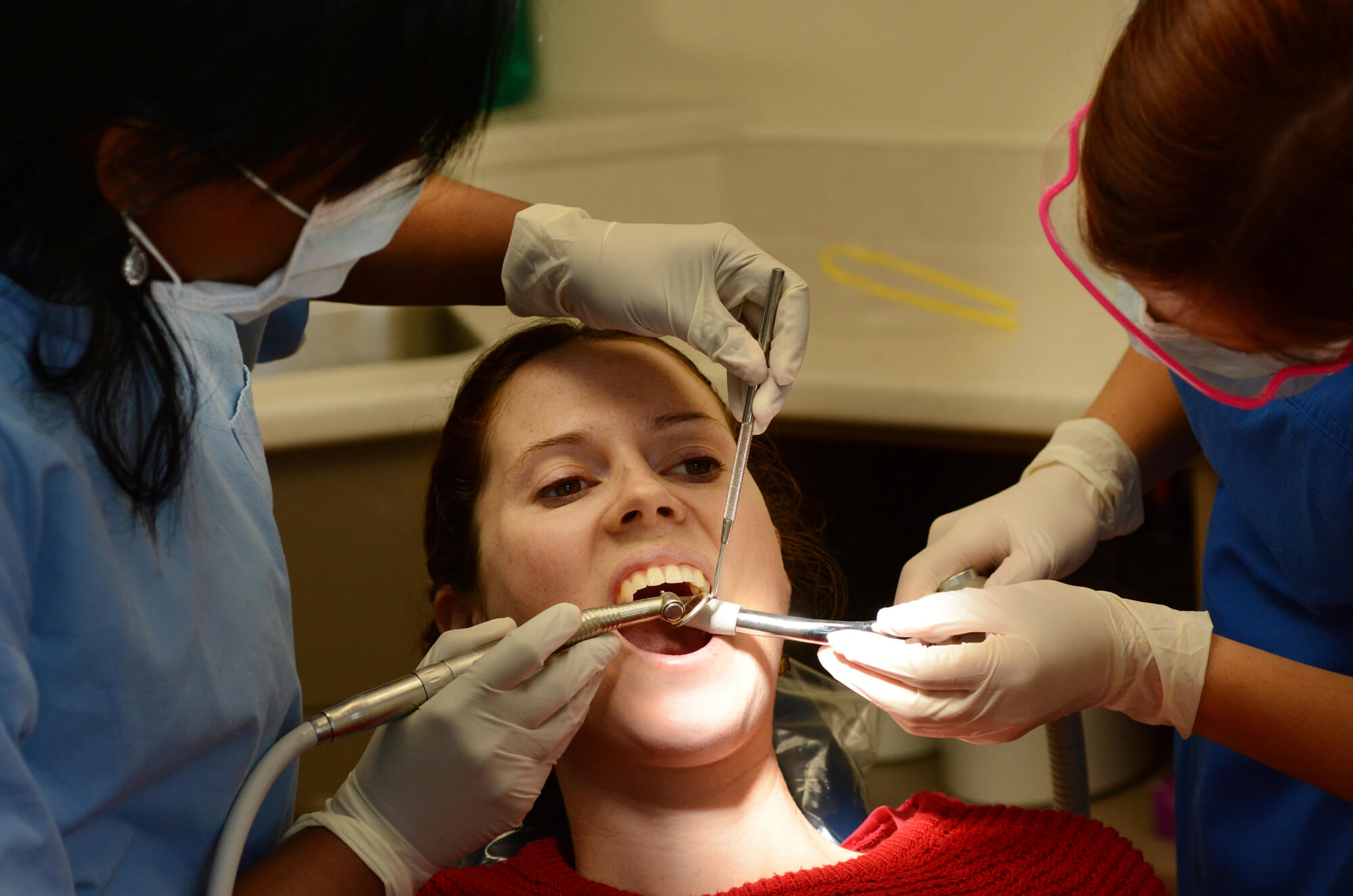 dentist in 33062 and his assistant works on a dental filling