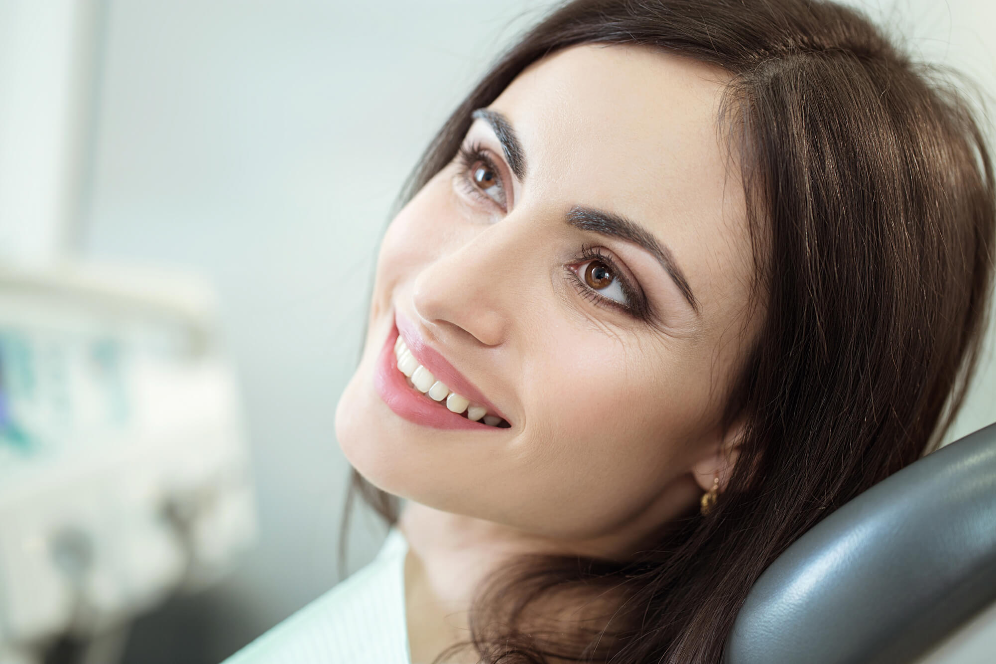 a woman on a dental chair smiling after appointment with a Cosmetic Dentist in Pompano Beach