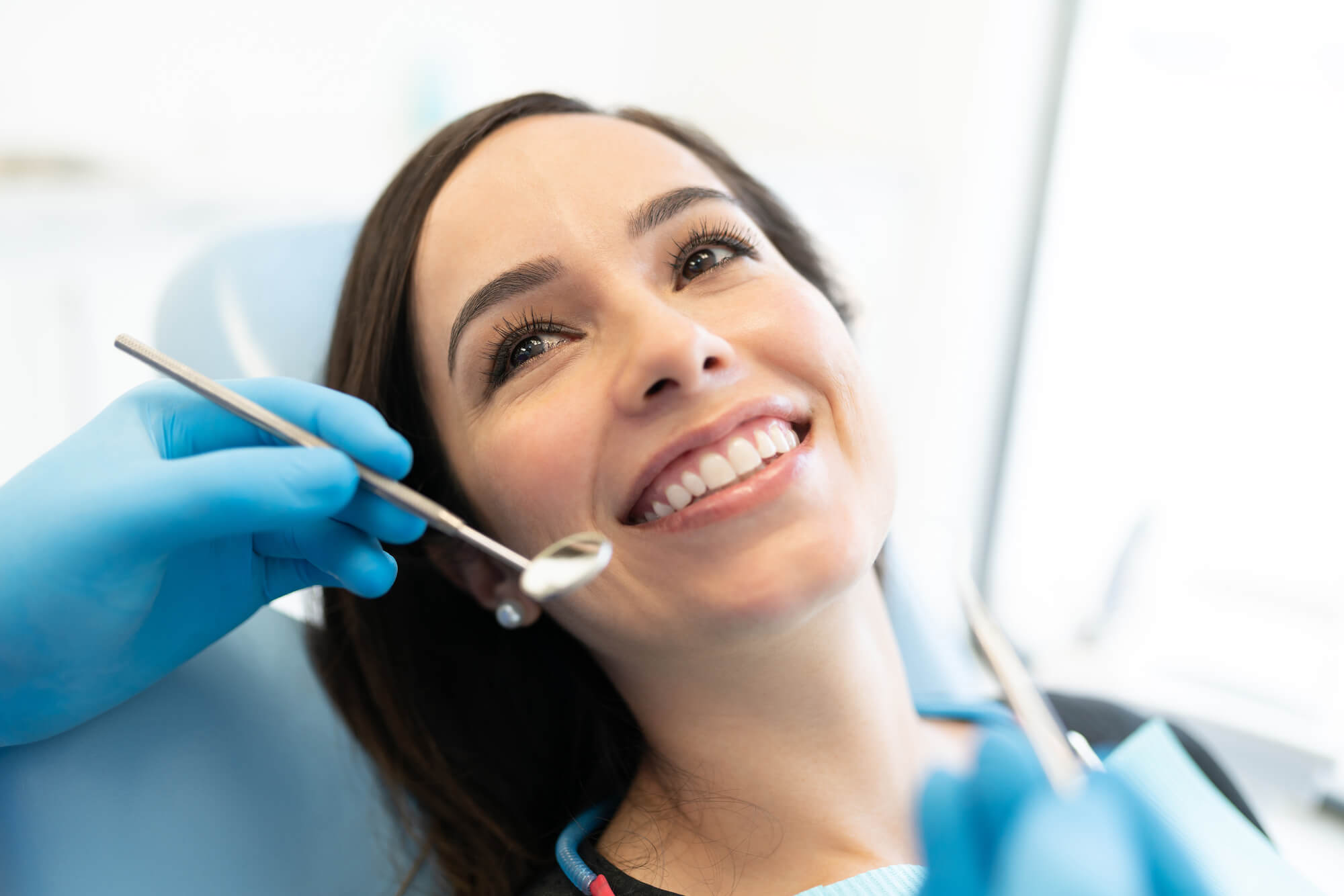 A woman at a dental chair smiling about to be examined by a Dentist in 33062
