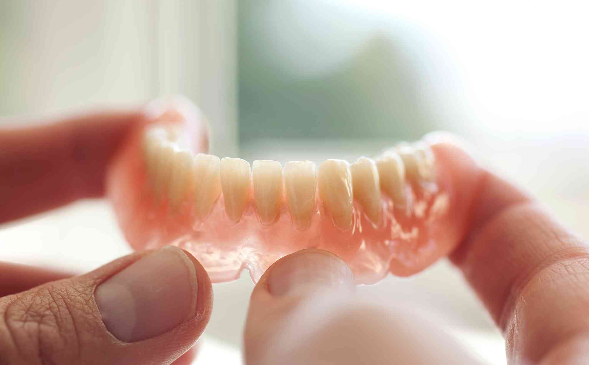 Dental technician working holding Dentures Pompano Beach
