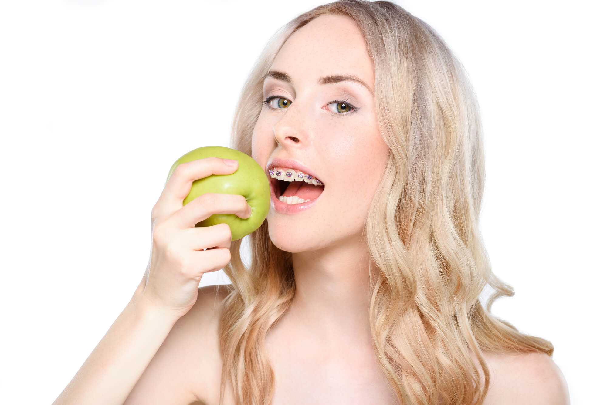 woman wearing Braces in Pompano Beach about to eat an apple